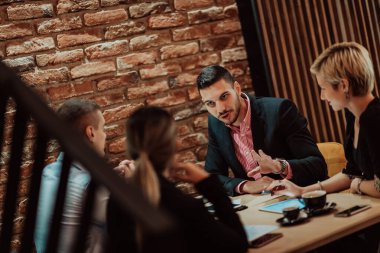 Happy businesspeople smiling cheerfully during a meeting in a creative office. Group of successful business professionals working as a team in a multicultural workplace. High quality photo