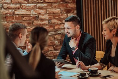 Happy businesspeople smiling cheerfully during a meeting in a creative office. Group of successful business professionals working as a team in a multicultural workplace. High quality photo