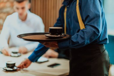 A waiter serves a group of business people in a cafe. Selective focus. High quality photo