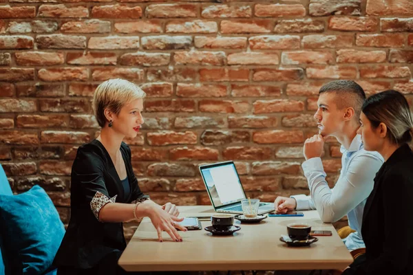 Happy businesspeople smiling cheerfully during a meeting in a creative office. Group of successful business professionals working as a team in a multicultural workplace. High quality photo