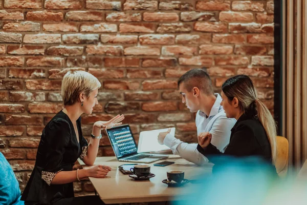 Happy businesspeople smiling cheerfully during a meeting in a creative office. Group of successful business professionals working as a team in a multicultural workplace. High quality photo