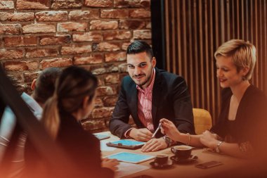 Happy businesspeople smiling cheerfully during a meeting in a creative office. Group of successful business professionals working as a team in a multicultural workplace. High quality photo