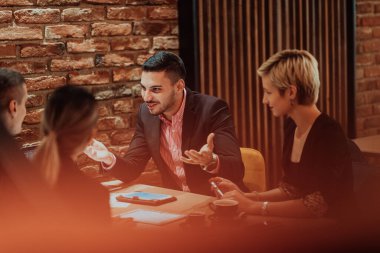 Happy businesspeople smiling cheerfully during a meeting in a creative office. Group of successful business professionals working as a team in a multicultural workplace. High quality photo
