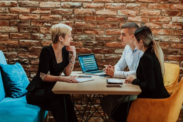 Happy businesspeople smiling cheerfully during a meeting in a creative office. Group of successful business professionals working as a team in a multicultural workplace. High quality photo