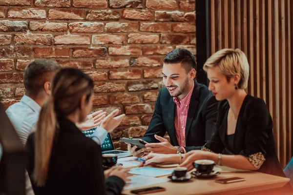 Happy businesspeople smiling cheerfully during a meeting in a creative office. Group of successful business professionals working as a team in a multicultural workplace. High quality photo