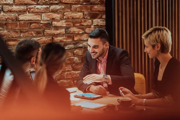 Happy businesspeople smiling cheerfully during a meeting in a creative office. Group of successful business professionals working as a team in a multicultural workplace. High quality photo