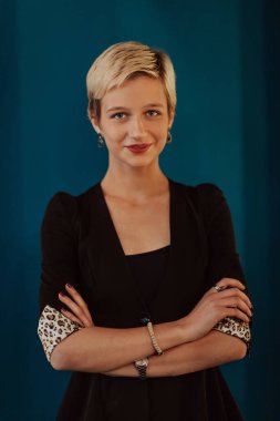 Pretty business woman, successful confidence with arms crossed on modern blue mat background. Selective focus. High quality photo