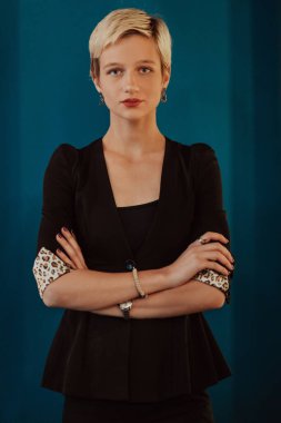 Pretty business woman, successful confidence with arms crossed on modern blue mat background. Selective focus. High quality photo