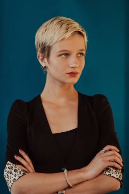 Pretty business woman, successful confidence with arms crossed on modern blue mat background. Selective focus. High quality photo