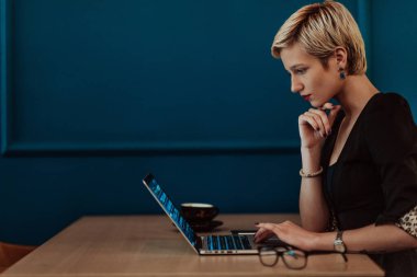 Businesswomen are stressed while working on laptops, Tired businesswomen with headaches in a coffee shop, and feeling sick at work. Selective focus. High quality photo
