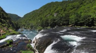 Fast extreme dive flight over the epic waterfall at exotic Una river aerial view. FPV sport drone speed movement nature at vegetation greenery wild environment. High quality 4k footage