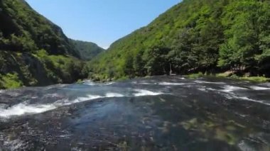 Fast extreme dive flight over the epic waterfall at exotic Una river aerial view. FPV sport drone speed movement nature at vegetation greenery wild environment. High quality 4k footage