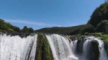 Fast extreme dive flight over the epic waterfall at exotic Una river aerial view. FPV sport drone speed movement nature at vegetation greenery wild environment. High quality 4k footage