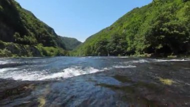 Fast extreme dive flight over the epic waterfall at exotic Una river aerial view. FPV sport drone speed movement nature at vegetation greenery wild environment. High quality 4k footage