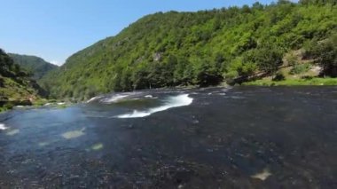 Fast extreme dive flight over the epic waterfall at exotic Una river aerial view. FPV sport drone speed movement nature at vegetation greenery wild environment. High quality 4k footage