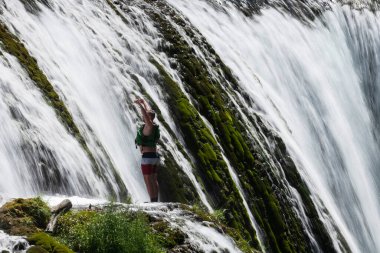 waterfall extreme brave man as superhero running jump and dive from the rock into the wild river water. High quality photo