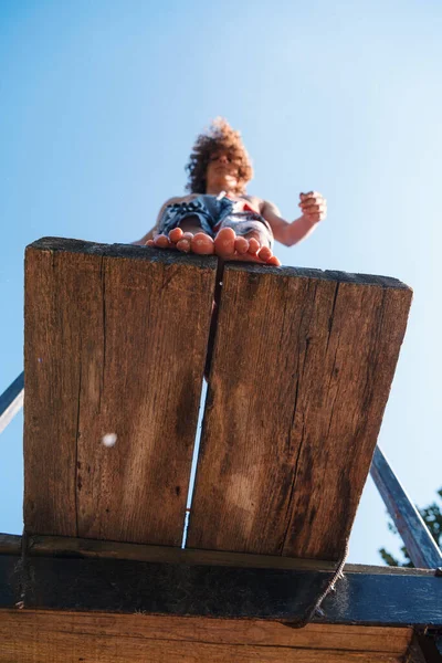 young teen boy ready for a jump in the river on a summer sunny day on vacation superhero shot with selective focus on water drops. High quality photo