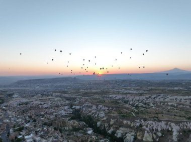 Aerial cinematic drone view of colorful hot air balloon flying over Cappadocia. Beautiful relaxing morning, summer sunrise, Anatolia region, Turkey