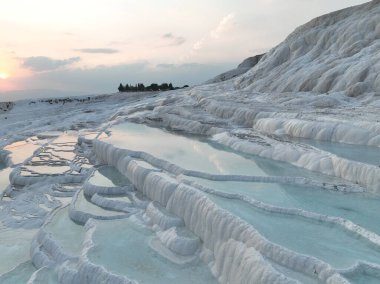 Pamukkale Travertines Cinematic Aerial Drone footage. Turkish famous white thermal bath with healthy clean water in a beautiful sunset. Aegean Region, Denizli Turkey
