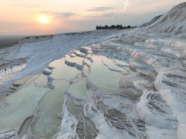 Pamukkale Travertines Cinematic Aerial Drone footage. Turkish famous white thermal bath with healthy clean water in a beautiful sunset. Aegean Region, Denizli Turkey