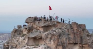 Aerial view of natural rock formations in the sunset, valley with cave houses in Cappadocia, Turkey. Natural landscape city lights at the night. Cinematic epic drone 4k hi quality footage.