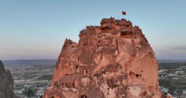 Aerial view of natural rock formations in the sunset, valley with cave houses in Cappadocia, Turkey. Natural landscape city lights at the night. Cinematic epic drone 4k hi quality footage.