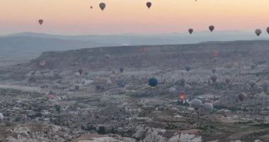 Aerial cinematic drone view of colorful hot air balloon flying over Cappadocia. Beautiful relaxing morning, summer sunrise, Anatolia region, Turkey