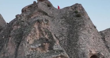 Aerial view of natural rock formations in the sunset, valley with cave houses in Cappadocia, Turkey. Natural landscape city lights at the night. Cinematic epic drone 4k hi quality footage.