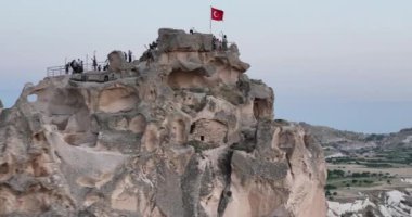 Aerial view of natural rock formations in the sunset, valley with cave houses in Cappadocia, Turkey. Natural landscape city lights at the night. Cinematic epic drone 4k hi quality footage.