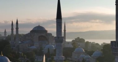 Istanbul, Turkey. Sultanahmet with the Blue Mosque and the Hagia Sophia with a Golden Horn on the background at sunrise. Cinematic Aerial view. Hi quality 4K footage.