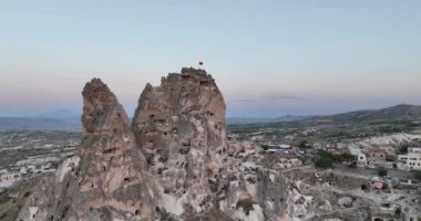 Aerial view of natural rock formations in the sunset, valley with cave houses in Cappadocia, Turkey. Natural landscape city lights at the night. Cinematic epic drone 4k hi quality footage.