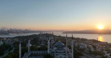 Istanbul, Turkey. Sultanahmet with the Blue Mosque and the Hagia Sophia with a Golden Horn on the background at sunrise. Cinematic Aerial view. Hi quality 4K footage.