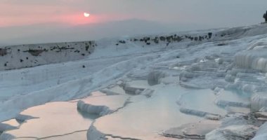 Pamukkale Travertines Cinematic Aerial Drone footage. Turkish famous white thermal bath with healthy clean water in a beautiful sunset. Aegean Region, Denizli Turkey