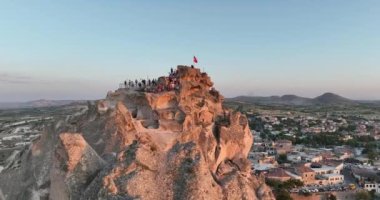 Aerial view of natural rock formations in the sunset, valley with cave houses in Cappadocia, Turkey. Natural landscape city lights at the night. Cinematic epic drone 4k hi quality footage.