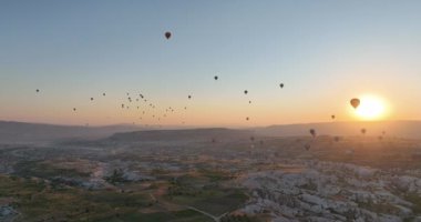 Aerial cinematic drone view of colorful hot air balloon flying over Cappadocia. Beautiful relaxing morning, summer sunrise, Anatolia region, Turkey