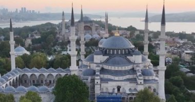 Istanbul, Turkey. Sultanahmet with the Blue Mosque and the Hagia Sophia with a Golden Horn on the background at sunrise. Cinematic Aerial view. Hi quality 4K footage.