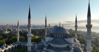 Istanbul, Turkey. Sultanahmet with the Blue Mosque and the Hagia Sophia with a Golden Horn on the background at sunrise. Cinematic Aerial view. Hi quality 4K footage.