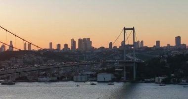 Istanbul Bosphorus Bridge and City Skyline in Background with Turkish Flag at Beautiful Sunset, Aerial slide orbiting and tracking shot. High quality cinematic 4k footage