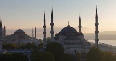 Istanbul, Turkey. Sultanahmet with the Blue Mosque and the Hagia Sophia with a Golden Horn on the background at sunrise. Cinematic Aerial view. Hi quality 4K footage.