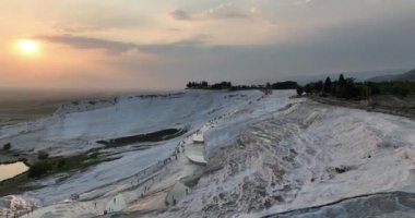 Pamukkale Travertines Cinematic Aerial Drone footage. Turkish famous white thermal bath with healthy clean water in a beautiful sunset. Aegean Region, Denizli Turkey
