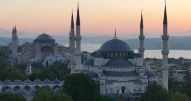 Istanbul, Turkey. Sultanahmet with the Blue Mosque and the Hagia Sophia with a Golden Horn on the background at sunrise. Cinematic Aerial view. Hi quality 4K footage.