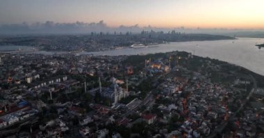 Istanbul, Turkey. Sultanahmet with the Blue Mosque and the Hagia Sophia with a Golden Horn on the background at sunrise. Cinematic Aerial view. Hi quality 4K footage.
