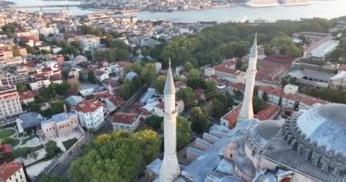Istanbul, Turkey. Sultanahmet with the Blue Mosque and the Hagia Sophia with a Golden Horn on the background at sunrise. Cinematic Aerial view. Hi quality 4K footage.
