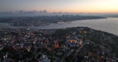 Istanbul, Turkey. Sultanahmet with the Blue Mosque and the Hagia Sophia with a Golden Horn on the background at sunrise. Cinematic Aerial view. Hi quality 4K footage.