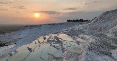 Pamukkale Travertines Cinematic Aerial Drone footage. Turkish famous white thermal bath with healthy clean water in a beautiful sunset. Aegean Region, Denizli Turkey