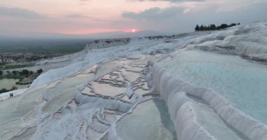 Pamukkale Travertines Cinematic Aerial Drone footage. Turkish famous white thermal bath with healthy clean water in a beautiful sunset. Aegean Region, Denizli Turkey