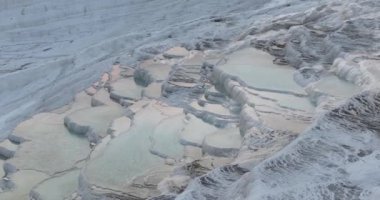 Pamukkale Travertines Cinematic Aerial Drone footage. Turkish famous white thermal bath with healthy clean water in a beautiful sunset. Aegean Region, Denizli Turkey