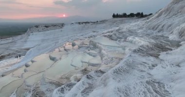 Pamukkale Travertines Cinematic Aerial Drone footage. Turkish famous white thermal bath with healthy clean water in a beautiful sunset. Aegean Region, Denizli Turkey