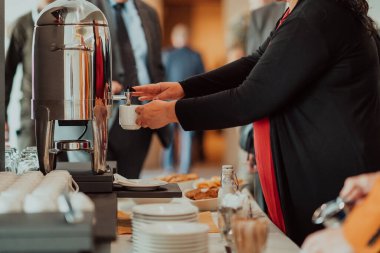 Close-up photo of businesswoman serving themselves in a modern hotel during a dinner party. Selective focus . High quality photo