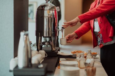 Close-up photo of businesswoman serving themselves in a modern hotel during a dinner party. Selective focus . High quality photo